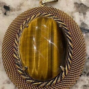 Oversized vibrant tiger eye pendant in gold tone setting